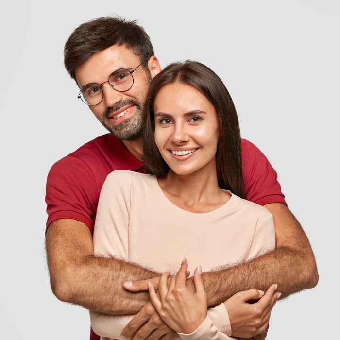 Man and woman embracing each other against a plain background