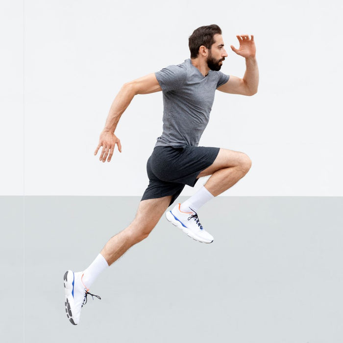 Man in athletic wear running on a light gray background