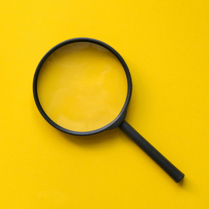 Black magnifying glass on a yellow background