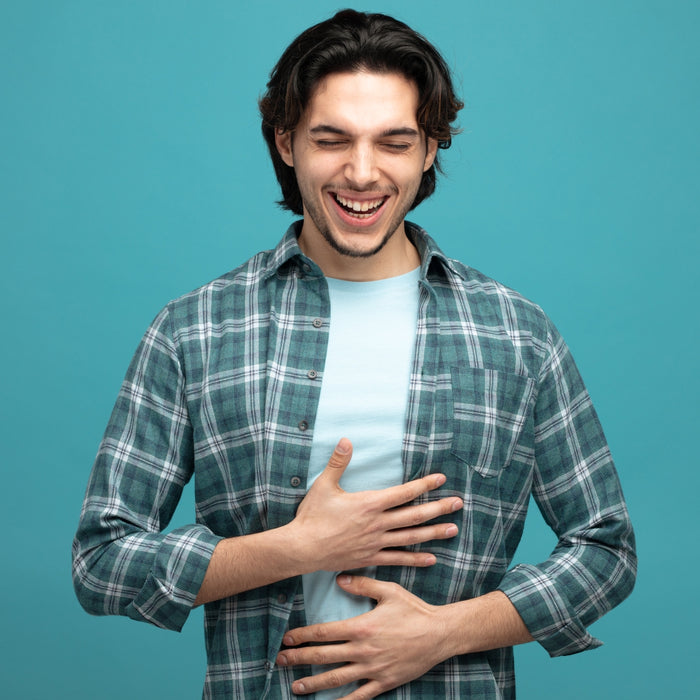 Man wearing a plaid shirt over a light blue t-shirt on a teal background
