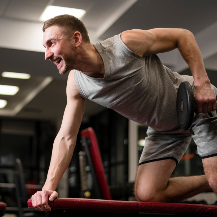 Man exercising with a dumbbell in a gym setting